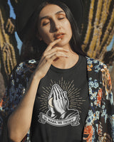 in masa we trust praying hands with masa ball on a black shirt from taco gear on hispanic female model