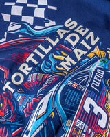 Taco Gear Al Pastor Racing t-shirt with colorful taco-themed racecar graphic, devil driver, and bold “Tacos de Trompo” and “Racing” text on navy and red tees.