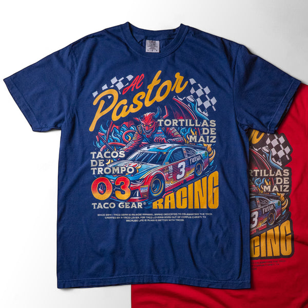 Taco Gear Al Pastor Racing t-shirt with colorful taco-themed racecar graphic, devil driver, and bold “Tacos de Trompo” and “Racing” text on navy and red tees.